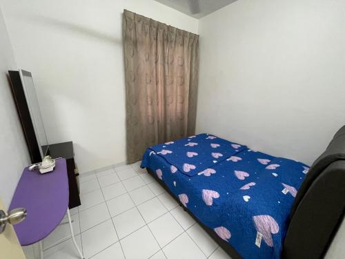 Dormitorio pequeño con cama con edredón azul en Homestay Yarmouk en Seremban