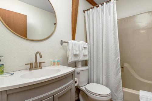 y baño con lavabo, aseo y espejo. en Ski Country 82A, en Sugar Mountain