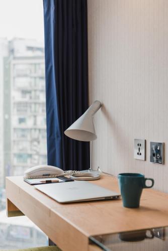 a desk with a lamp and a cup on it at Hej Taipei in Taipei