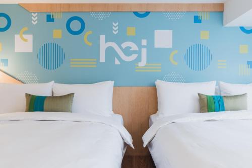 two beds in a room with blue and yellow wall at Hej Taipei in Taipei