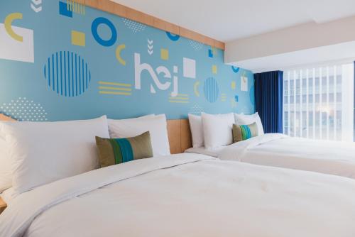 two beds in a bedroom with a blue wall at Hej Taipei in Taipei