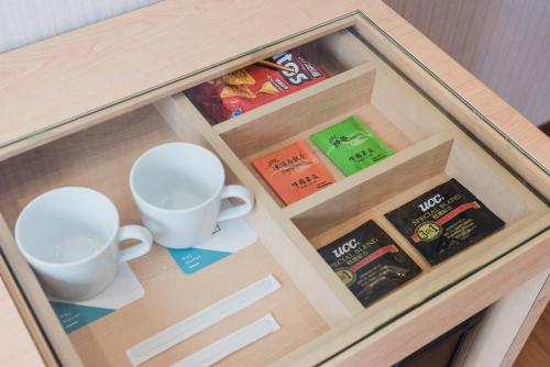 a wooden drawer with two cups and books on it at Hej Taipei in Taipei