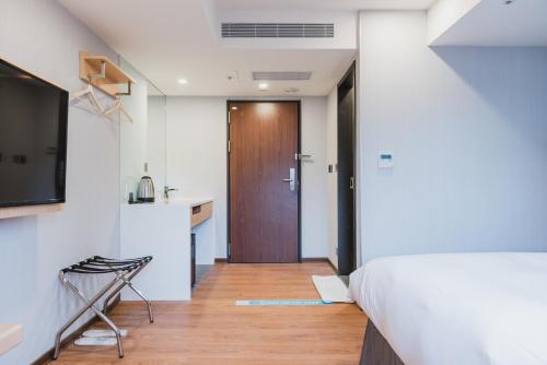 a bedroom with a bed and a wooden floor at Hej Taipei in Taipei