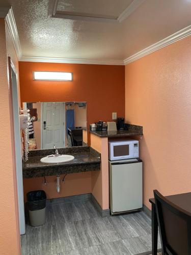 a small kitchen with a sink and a microwave at Budget Motel in Mountain View