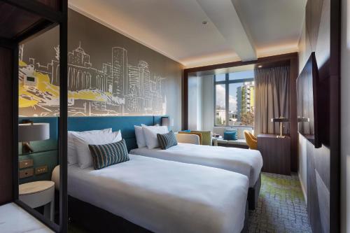 a hotel room with two beds and a window at Mercure Auckland Queen Street in Auckland