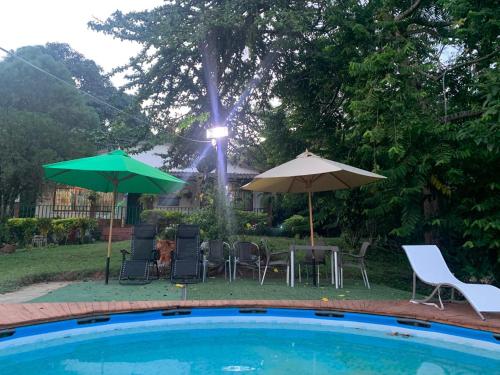 a pool with chairs and tables and umbrellas at Eco-Glamping Shalom in Mariquita