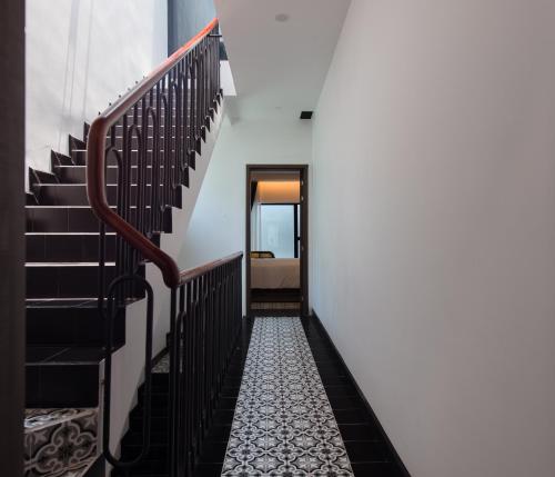 a hallway of a house with black stairs at Khách sạn gần biển Miami Tuy Hoà Phú Yên in Liên Trì (3)