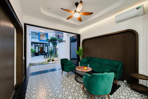 a living room with a green couch and a table at Khách sạn gần biển Miami Tuy Hoà Phú Yên in Liên Trì (3)