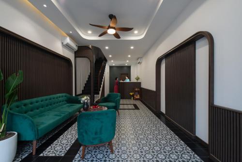 a living room with a green couch and a ceiling fan at Khách sạn gần biển Miami Tuy Hoà Phú Yên in Liên Trì (3)