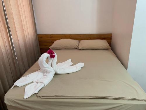 a small bed with two towels on it at La Hacienda Rooms & Food in Jacó