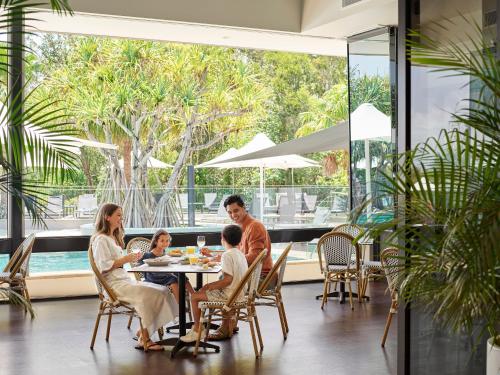 una famiglia seduta a un tavolo in un ristorante di RACV Noosa Resort a Noosa Heads