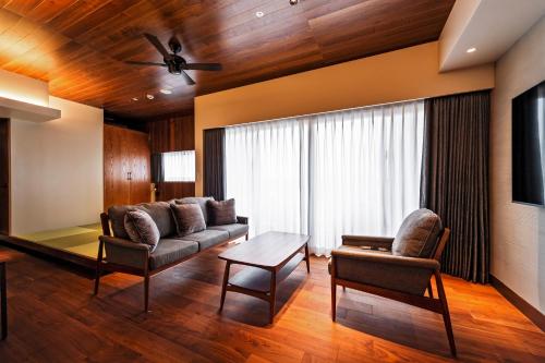 a living room with a couch and a table at PROSTYLE TERRACE NAHA in Naha