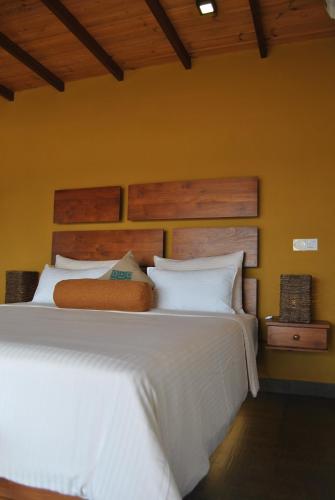 a bedroom with a large bed with white sheets at The Canoe in Negombo