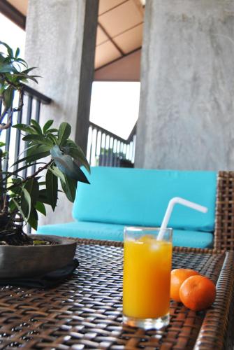 a glass of orange juice sitting on a table with oranges at The Canoe in Negombo