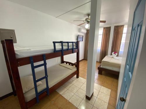 two bunk beds in a room with a bedroom at La Hacienda Rooms & Food in Jacó