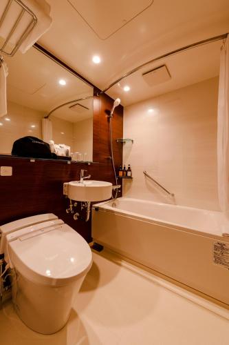 a bathroom with a toilet and a tub and a sink at PROSTYLE TERRACE NAHA in Naha