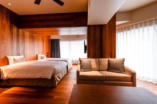 a bedroom with a large bed and a couch at PROSTYLE TERRACE NAHA in Naha