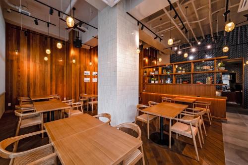 a dining room with wooden tables and chairs at PROSTYLE TERRACE NAHA in Naha