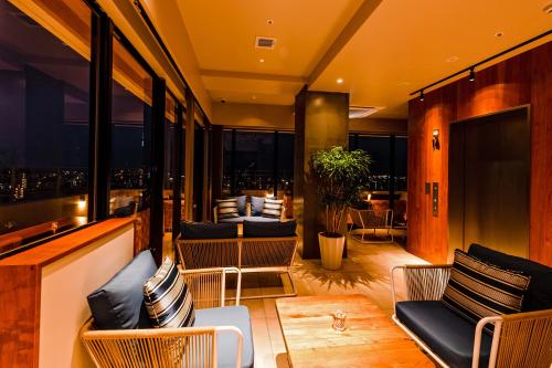 a hotel lobby with chairs and a view of the city at PROSTYLE TERRACE NAHA in Naha