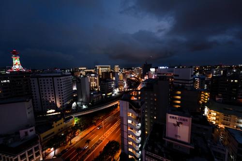 a city lit up at night with traffic on the street at PROSTYLE TERRACE NAHA in Naha