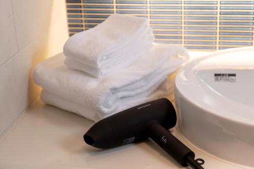 a hair dryer sitting next to a pile of towels at PROSTYLE TERRACE NAHA in Naha