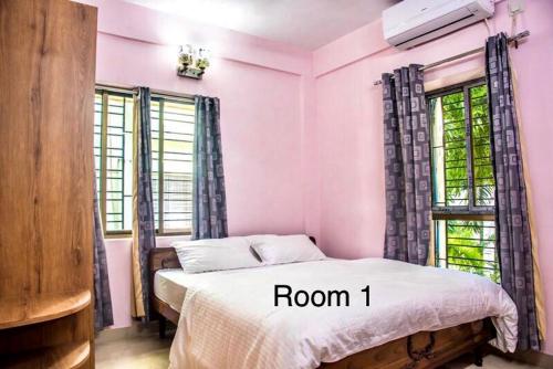 um quarto com paredes cor-de-rosa e uma cama com quarto em Ruby by Olys Apartment em Calcutá