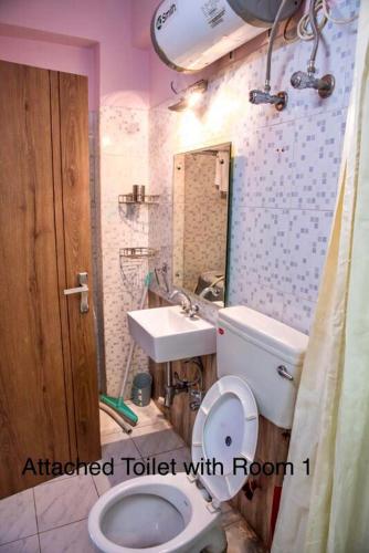 a bathroom with a toilet and a sink at Ruby by Olys Apartment in Kolkata