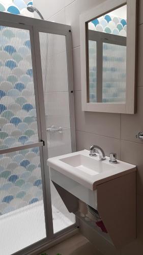 a bathroom with a sink and a mirror and a shower at Patagonia Apart in Paraná