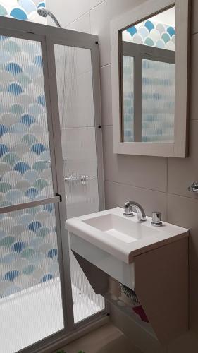 une salle de bain avec un lavabo, un miroir et une douche dans l'établissement Patagonia Apart, à Paraná