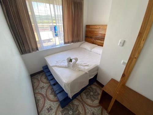 a small room with a bed with a swan on it at La Hacienda Rooms & Food in Jacó