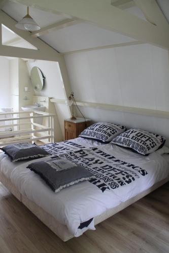 a bedroom with a large bed with black and white pillows at Summerhouse Zandvoort in Zandvoort