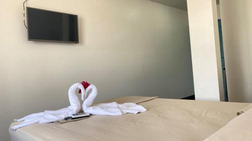 a swan made out of towels sitting on a bed at La Hacienda Rooms & Food in Jacó