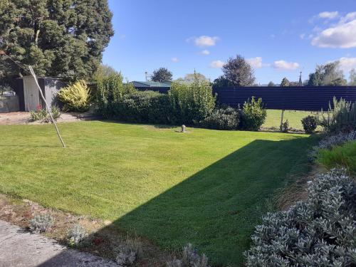 a yard with a large lawn with a large shadow at Ellie's Villa in Brydone
