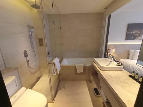 a bathroom with a shower and a toilet and a sink at Riverview Suites Taipei in Taipei