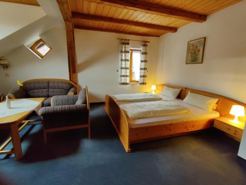 a bedroom with a bed and a table and a chair at Pension Berg&Bleibe Wertach in Wertach