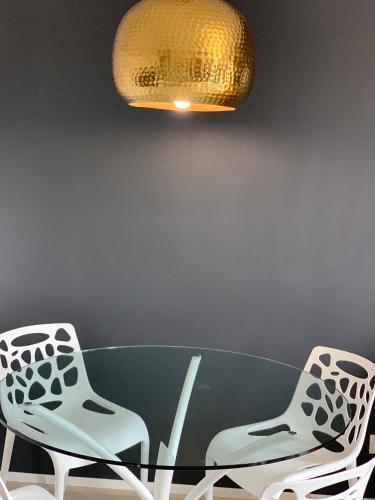 a dining room table with two chairs and a chandelier at Sopocka Bryza in Sopot