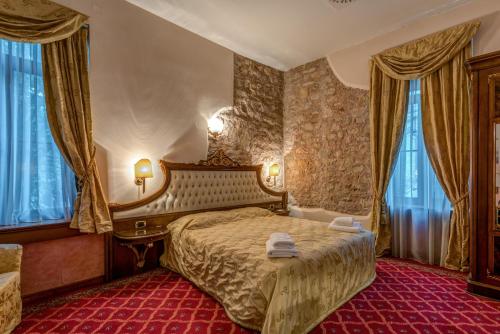 A bed or beds in a room at Alexios Luxury Hotel