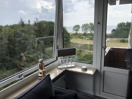 a living room with a large window with a table and glasses at Appartement Strandnest Meerblick strandnah by Unsere Urlaubszeit in Grömitz