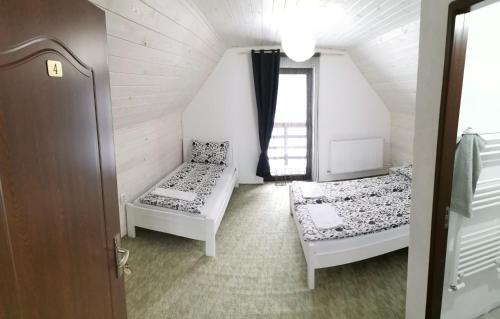 a small room with two beds and a window at Izvorul Prigoanei in Tău Bistra