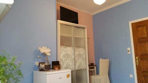 a room with a glass cabinet and a white refrigerator at center apartments in Lefkada Town
