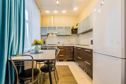 a kitchen with a table and chairs and a refrigerator at 2к квартира на Басейній, ТРЦ Гуллівер in Kyiv