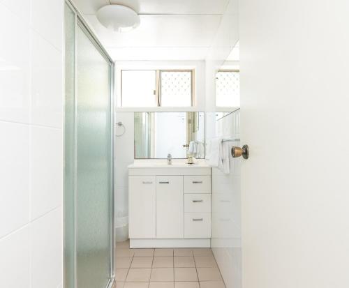 a white bathroom with a sink and a mirror at Yamba Towers 2 - LJHooker Yamba in Yamba