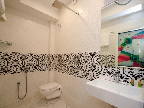 Hotel Golden Palace في كولْكاتا: حمام مع مرحاض ومغسلة ومرآة