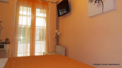 a bedroom with a bed and a television on the wall at center apartments in Lefkada Town