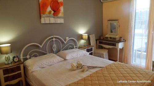 a bedroom with a large white bed with flowers on it at center apartments in Lefkada Town