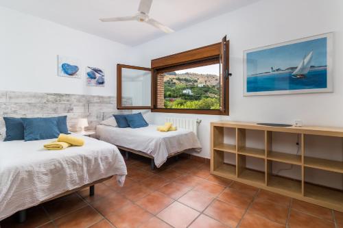 a room with two beds and a window at Finca Limón in Pizarra