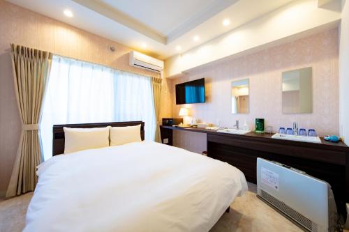 a bedroom with a large bed and a sink at VILLA KOSHIDO kotoni in Sapporo