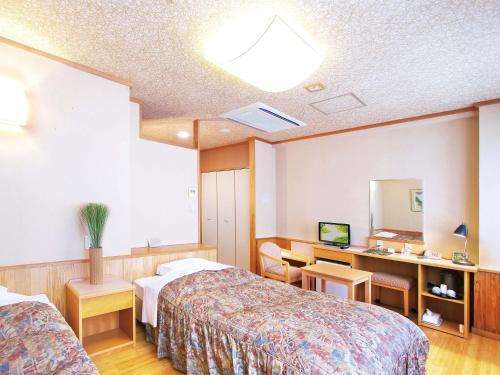 a hotel room with two beds and a mirror at Hotel Daikokuya in Yatsushiro
