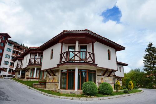 a large house with a balcony on a street at Forest Nook Villas in Pamporovo