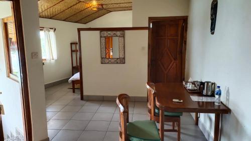 a dining room with a wooden table and chairs at Bayview Gardens Hotel in Labuan Bajo